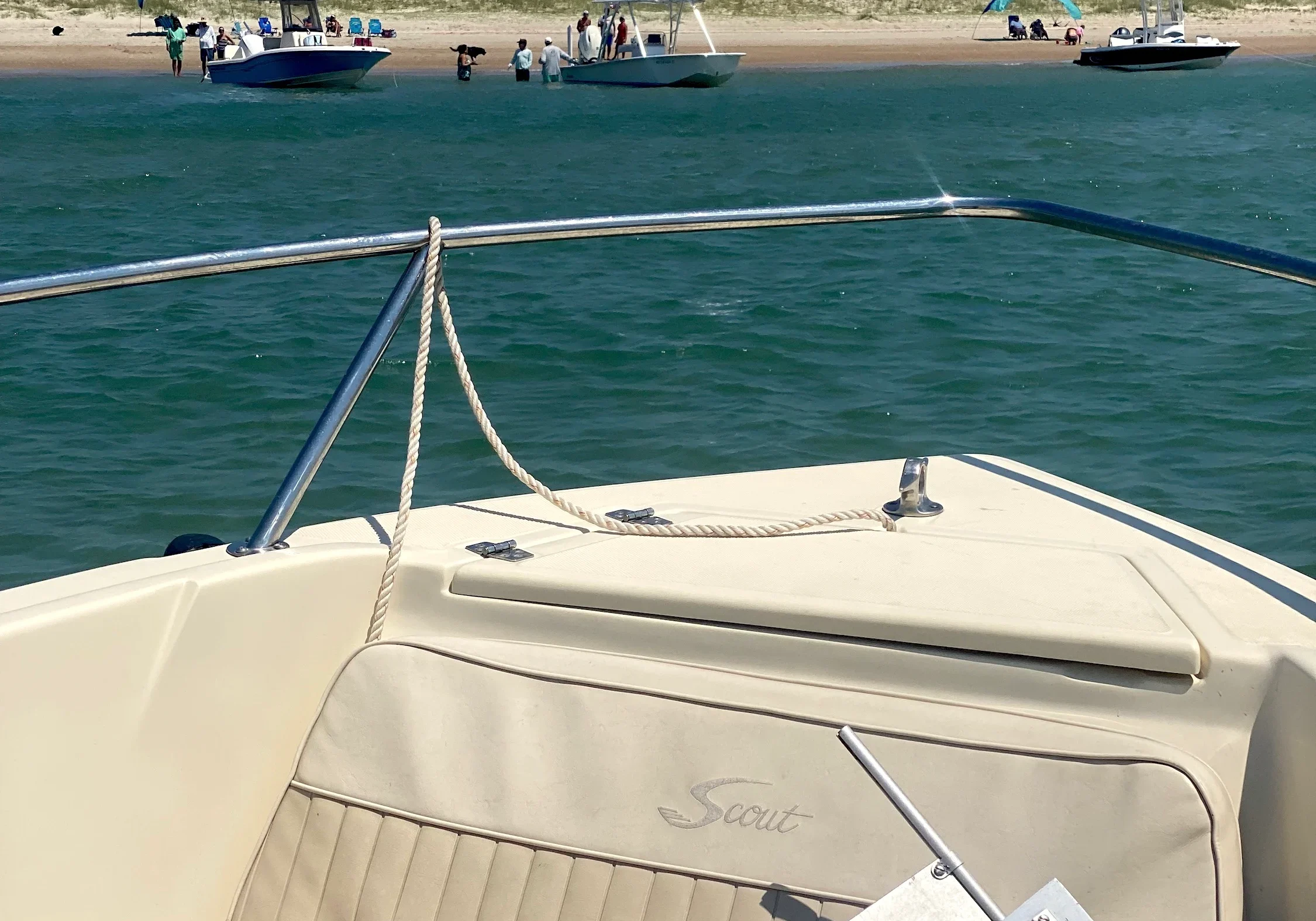 Boat anchored near a sunny beach scene.